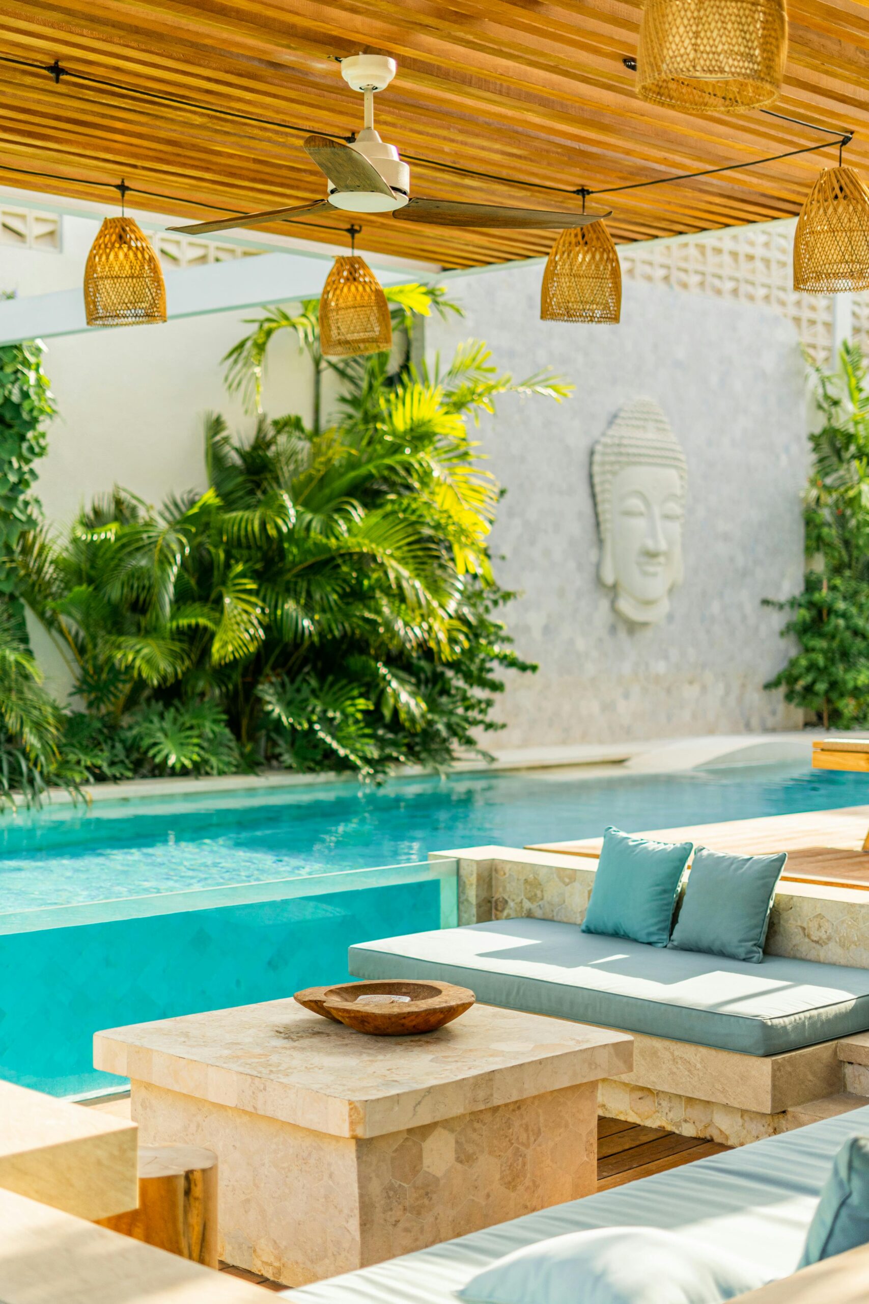 Elegant outdoor pool area featuring tropical plants and modern seating for relaxation.
